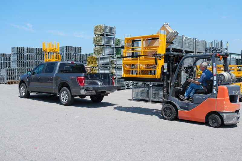 Worker loads scaffolding into pickup truck