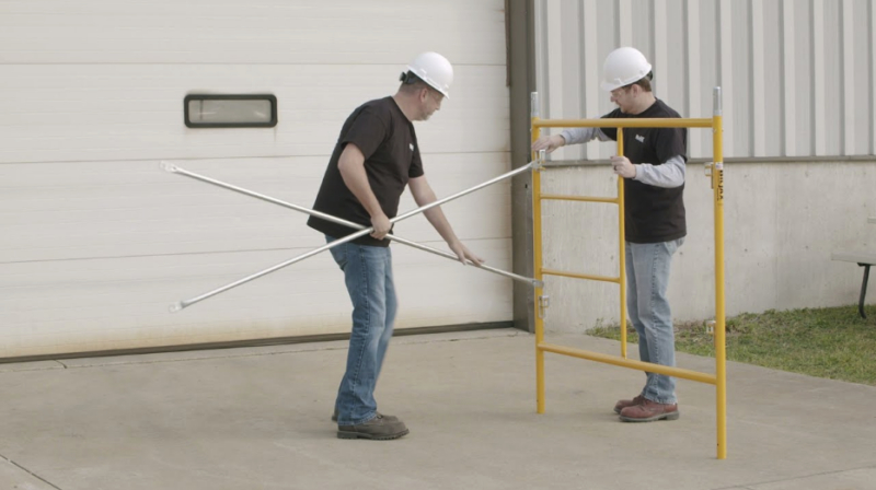 Employees assemble scaffolding
