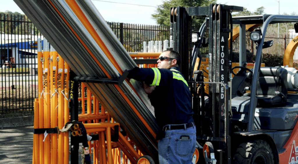 A worker unloads an EX-Rax Scaffold storage system at a site.