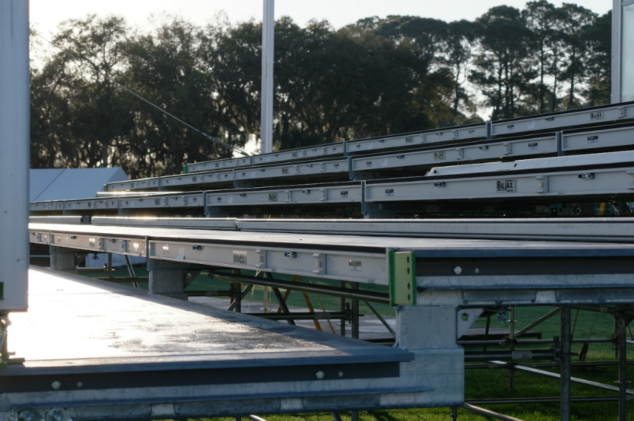 Close view of raised metal event seating platforms supported by a strong frame on an outdoor field.